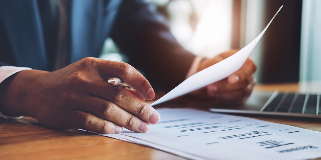 close up photograph of a person's hands holding a resume