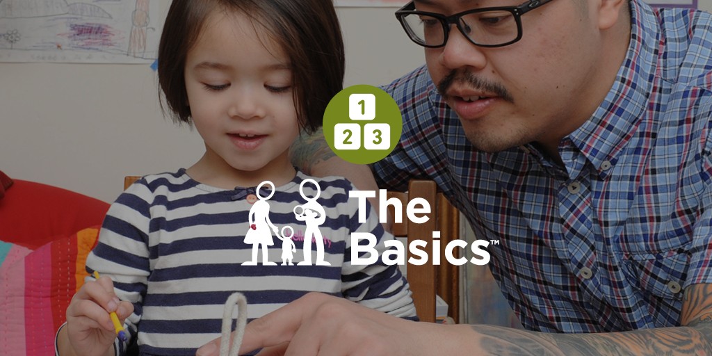 A photograph of parent and child working together on a craft project. A green icon with three numbered blocks sits above the logo for The Basics. 