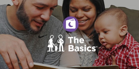 Photograph of two parents and a baby sitting close together and looking at a book with the Basics logo over top. 