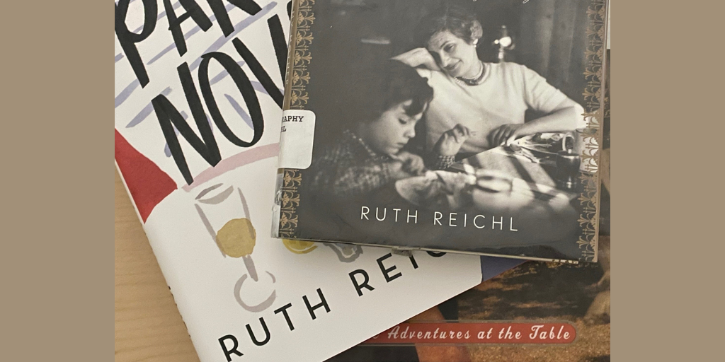 A close-up photograph features three Ruth Reichl books stacked on top of each other. 