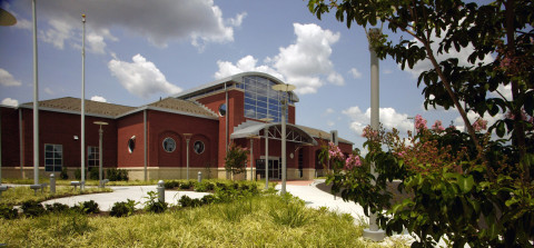 The front exterior view of a large two-story red brick building. 